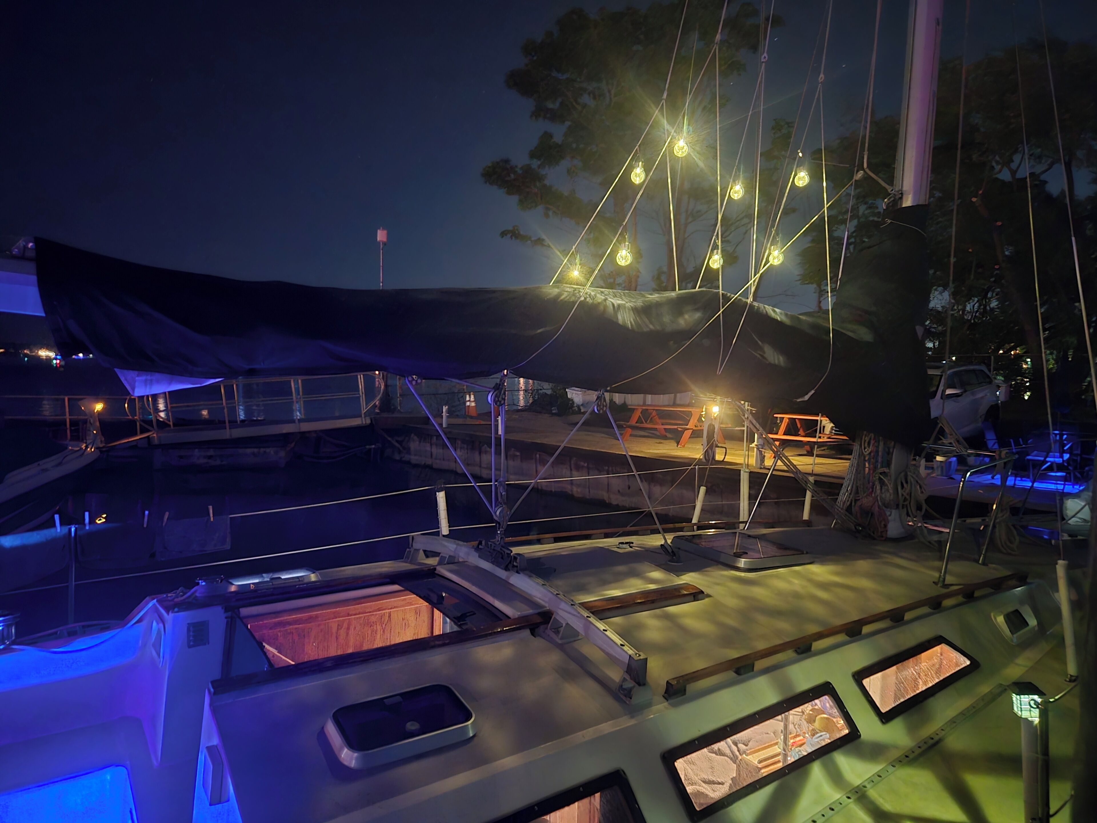 A boat deck with a covered area, a table, and a railing.