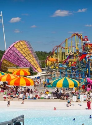 Um parque aquático com piscina, toboáguas e montanha-russa.