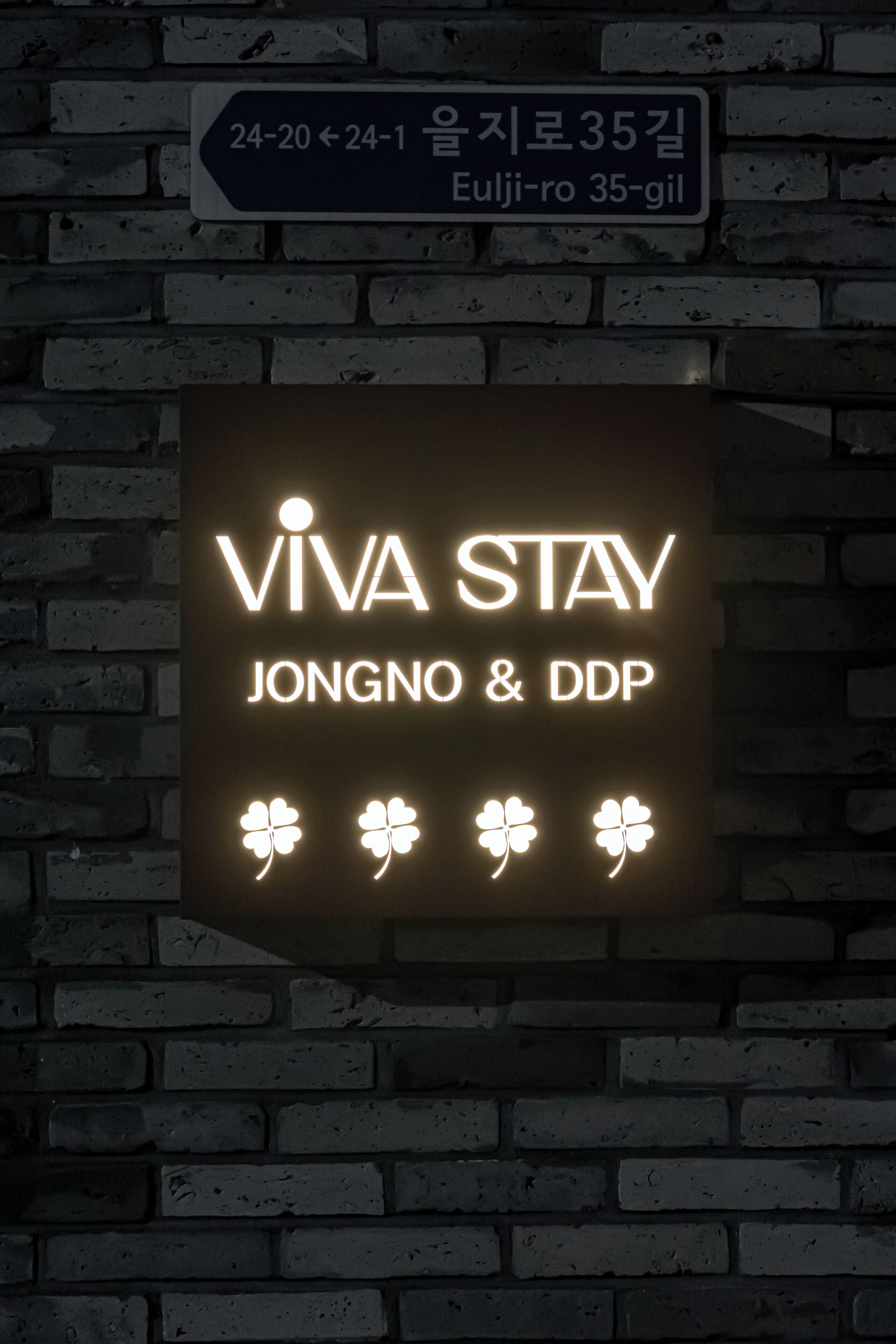 Un letrero con 'VIVA STAY JONGNO & DDP' y cuatro símbolos de trébol.