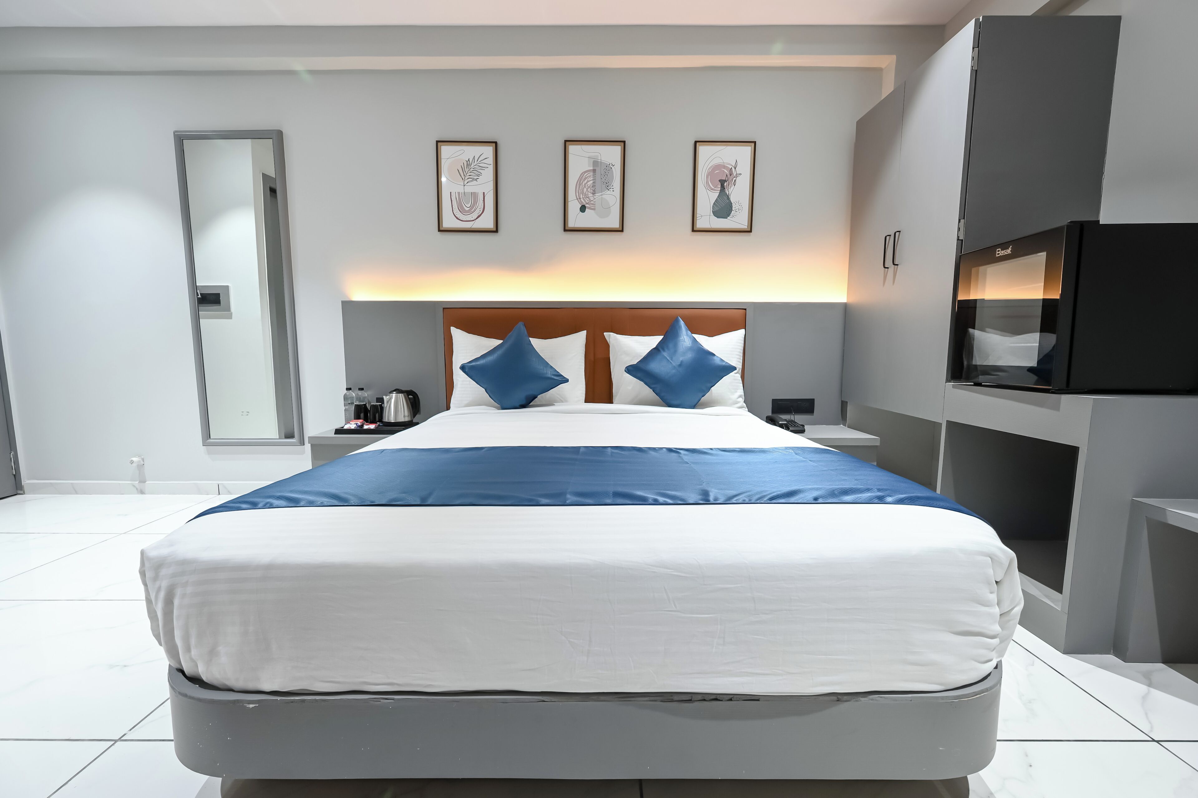 Een moderne hotelkamer met een groot bed, een flatscreen televisie en een nachtkastje.