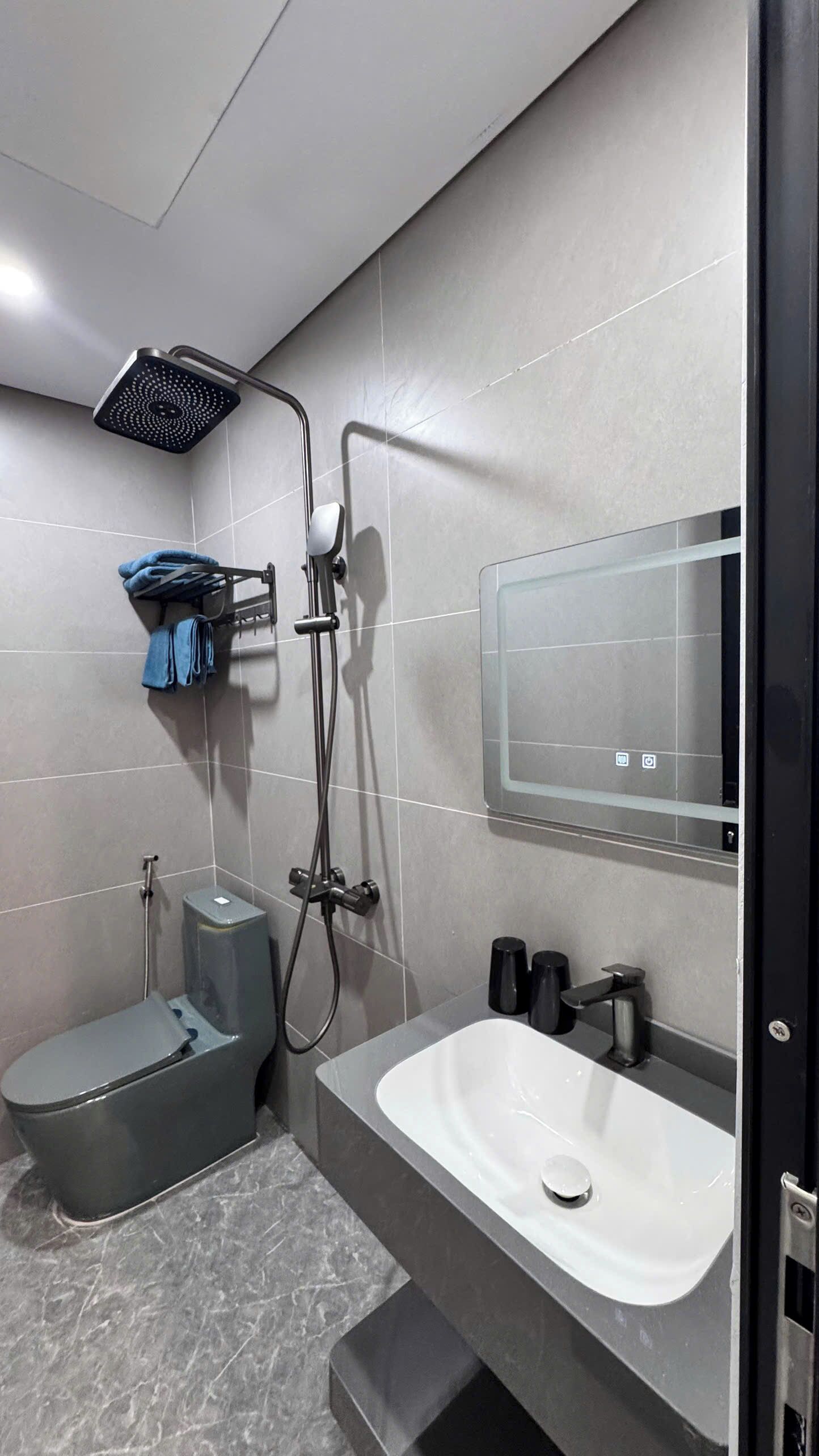 Un baño moderno con ducha, inodoro y lavamanos.