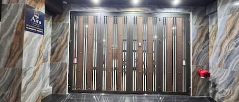 Un ascensor moderno con pared de mármol y un cartel que indica 'Airy Stay' a la izquierda.
