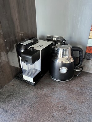 A coffee machine and a kettle on a countertop. - Luxury Clifftop Beach House: Panoramic Sea Views, FREE Hot Tub & Games Room (Cayton Bay)