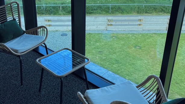 A balcony with wicker furniture, a glass table, and a view of the ocean. - Luxury Clifftop Beach House: Panoramic Sea Views, FREE Hot Tub & Games Room (Cayton Bay)