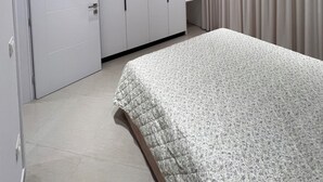 Ein Schlafzimmer mit Bett, Kleiderschrank und Vorhängen.