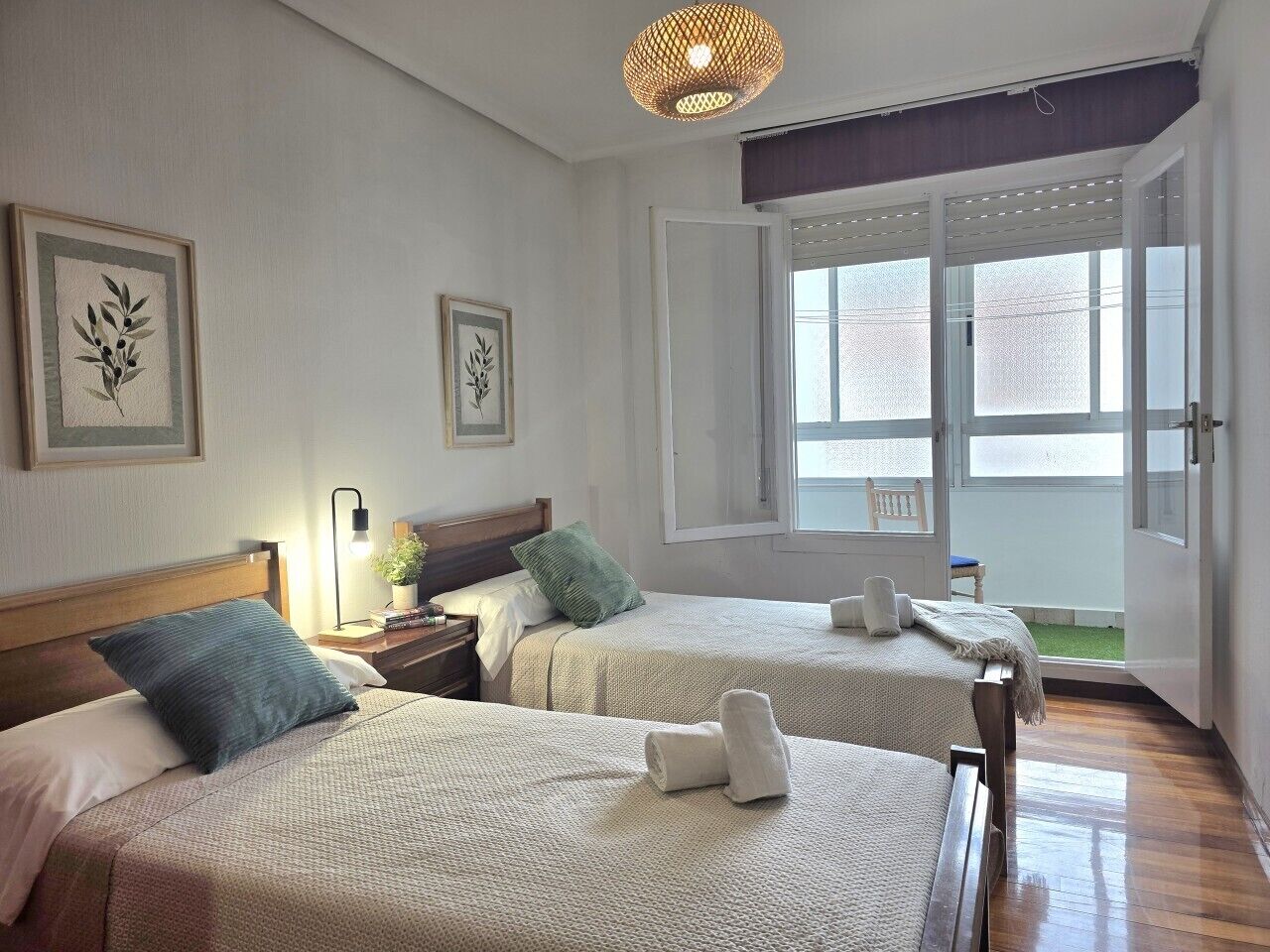 Une chambre d’hôtel avec deux lits, une fenêtre et une porte donnant sur l’extérieur.