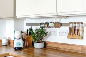A kitchen with a coffee maker, a potted plant, and a knife block. - The Riverside Haven – City Centre + Parking (Newport)