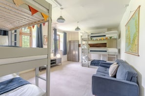 A room with bunk beds, a desk, a wardrobe, and a map on the wall. - 1641 Historic Farmhouse, Sleeps 16 · Bath/Bristol (Keynsham)