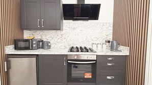 Eine kleine Küche mit Mikrowelle, Toaster, Gasherd und Backofen.