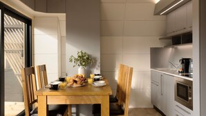 Una cucina compatta con zona pranzo, dotata di elettrodomestici moderni e angolo colazione.