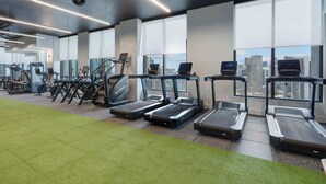 A gym with treadmills, exercise bikes, and a green carpeted area. - Luxury 2BR | Downtown Miami Condo | Rooftop Pool (Miami)