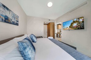 Ein Hotelzimmer mit einem Bett, einem Fernseher und einem Bild an der Wand.