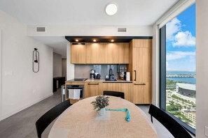 Eine moderne Küche mit Holzausstattung, einer Kaffeemaschine und Blick auf die Stadt.