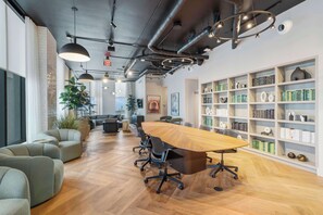 A modern meeting room with a long wooden table, black chairs, and a bookshelf filled with books. - Luxury 2BR | Downtown Miami Condo | Rooftop Pool (Miami)