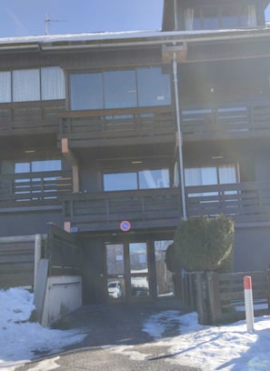 Ein mehrgeschossiges Gebäude mit einem befestigten Eingang, einem Verbotsschild und einem mit Schnee bedeckten Gelände.
