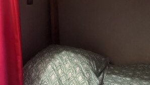 En våningssäng med ett mönstrat madrass och en huvudgavel i trä.