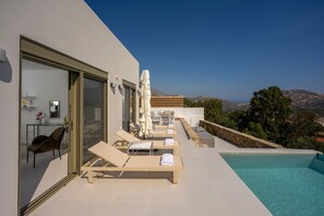 A modern outdoor pool area with lounge chairs and a view of the landscape. - Aurea Kalithea Sunset  Sunrise  Sea (Asomatos)