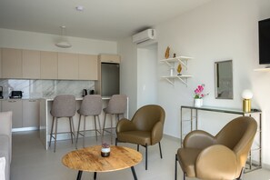Ein modernes Wohnzimmer mit Couchtisch aus Holz, Ledersesseln und einem Glastisch.