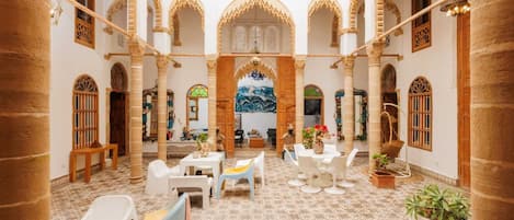 An interior courtyard with arches, a fountain, and seating areas.