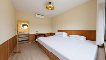 Ett hotellrum med en säng, ett sängbord, en spegel och en taklampa.