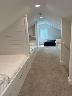A bedroom with two beds, a window, and a carpeted floor. - Steps to Beach! Newly Renovated 4BR Lakeview w Wrap Porch Game Garage Fire Pit (South Haven)