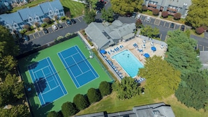 An aerial view of a residential area with a tennis court, a swimming pool, and a parking lot. - Eagle Way 2 - Access to Pools (Rehoboth Beach)