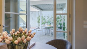 A modern room with a glass door leading to an outdoor patio. - The Secret Garden Cottage (Lucca)