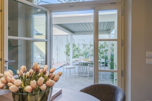 Ein modernes Zimmer mit Glastür und Zugang zu einer Außenpatio.