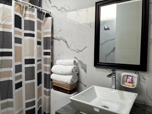 Superior kamer | Badkamer | Een douche, handdoeken, zeep, shampoo