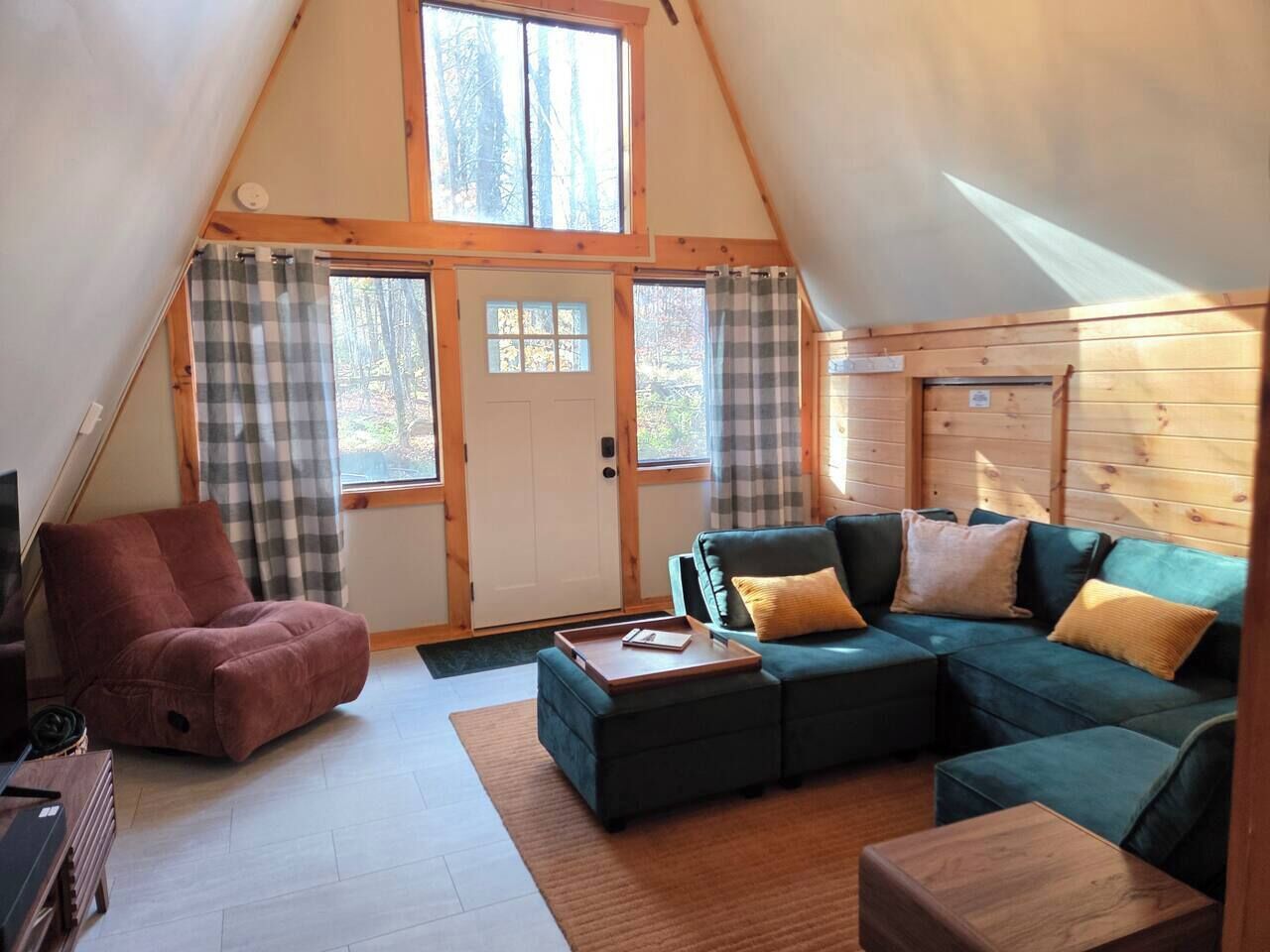 Un acogedor loft con un sofá seccional, un sillón individual y una mesa de centro de madera.