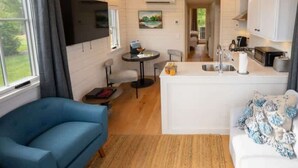 A compact living space with a kitchenette, a dining area, and a sofa.