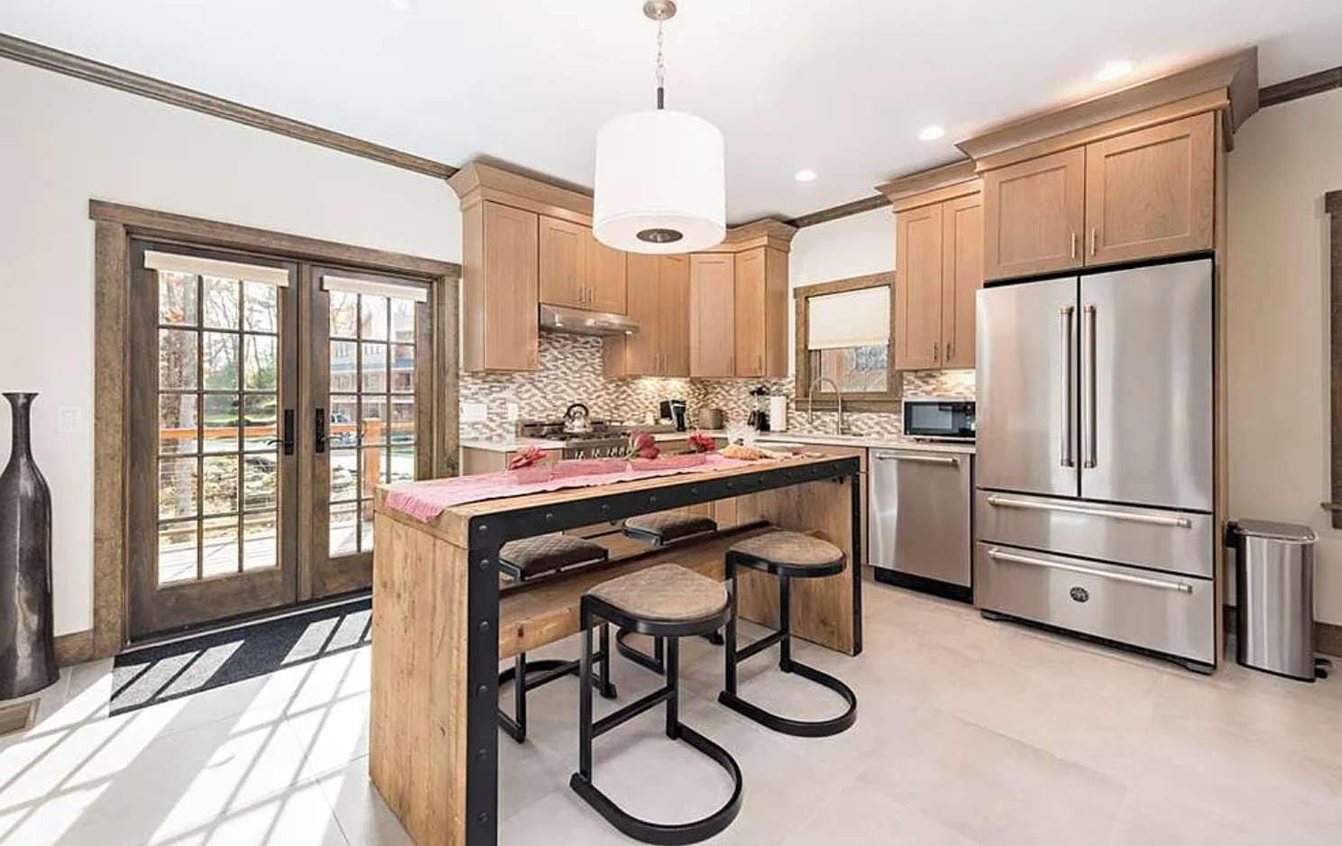 A modern kitchen with a central island, stainless steel appliances, and wooden cabinetry.
