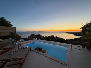 A swimming pool with a view of the sea and a sunset. - Villa 'Dimora Egle' with Private Terrace, Wi-Fi and Air Conditioning (Quartu Sant'Elena)