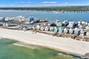 A coastal hotel with multiple buildings, a beach, and a marina. - Cottages at Lagoon Pass D | Walk to the Beach (Gulf Shores)