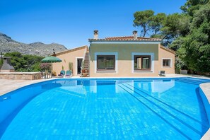 En swimmingpool med ett hus i bakgrunden.