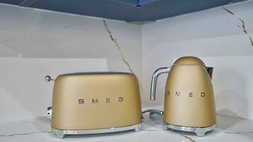 Two golden appliances with the brand name 'SNEO' on them, placed on a white tiled surface.