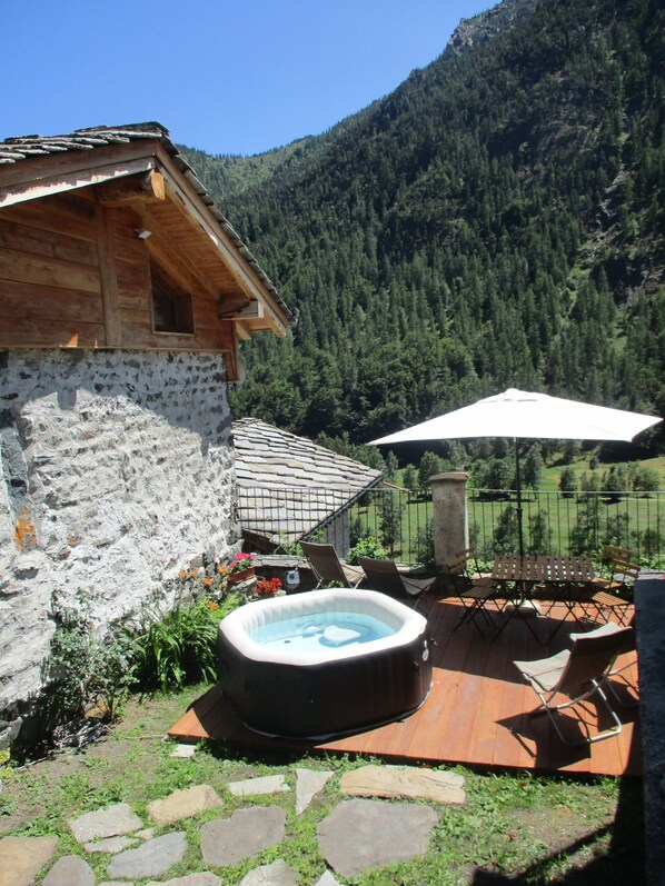 Une cabane en bois dotée d’un bain à remous, d’un espace extérieur aménagé et offrant une vue sur les montagnes.