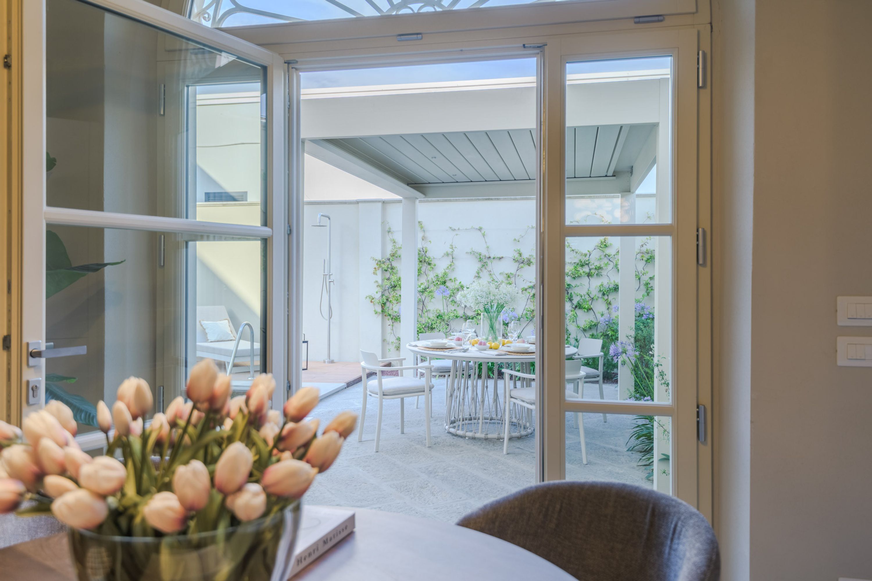 Ein moderner Innenraum mit Glastür zu einer Außenpatiofläche.