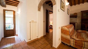 A hallway with a radiator, a wooden door, and a sofa.