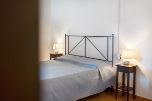 Ein Schlafzimmer mit einem Bett, zwei Nachttischen und einer Hängelampe.