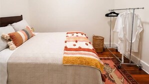 Un dormitori amb un llit, una estant de roba i una catifa.