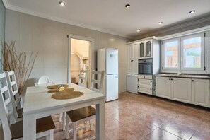 Eine moderne Küche mit weißen Schränken, einem eingebauten Backofen und einem Fenster mit Blick auf den Garten.
