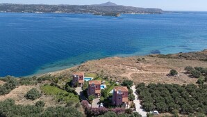Ein Küstenanwesen mit freiem Blick auf das Meer, einer hügeligen Landschaft und einem fernen Berg.