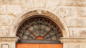 A double wooden door with a metal arch above it, set in a stone wall. - La Casa sul Corso - In the Heart of Foiano della Chiana (Foiano della Chiana)