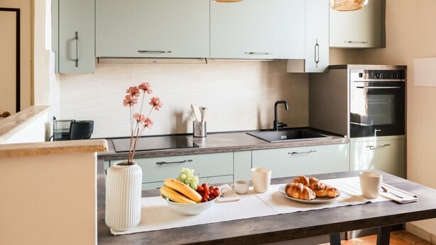 A modern kitchen with light blue cabinets, a stainless steel sink, and an oven. - La Casa sul Corso - In the Heart of Foiano della Chiana (Foiano della Chiana)