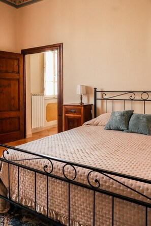Una camera da letto con un letto, un comodino, una lampada e una porta in legno.