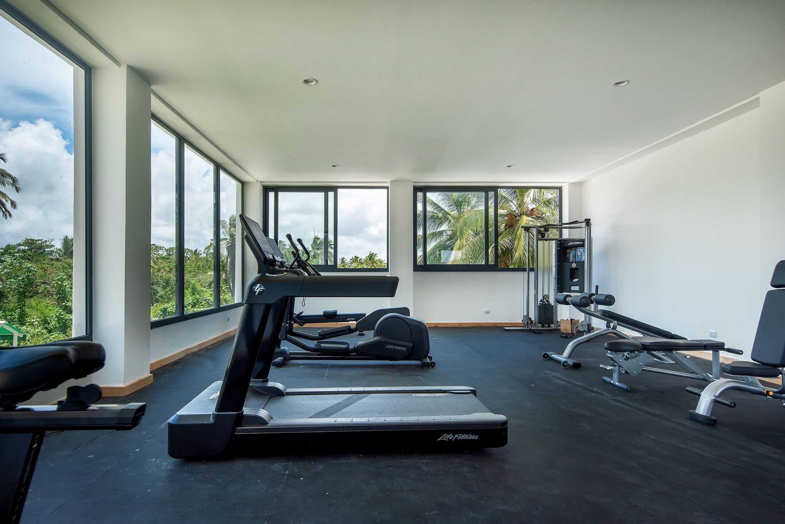 A gym with treadmills, elliptical machines, and weight equipment.