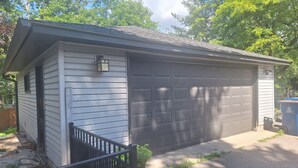 A single-story building with a garage, a small porch, and a metal fence. - Spacious 5-bedroom house in Bloomington (Minneapolis)