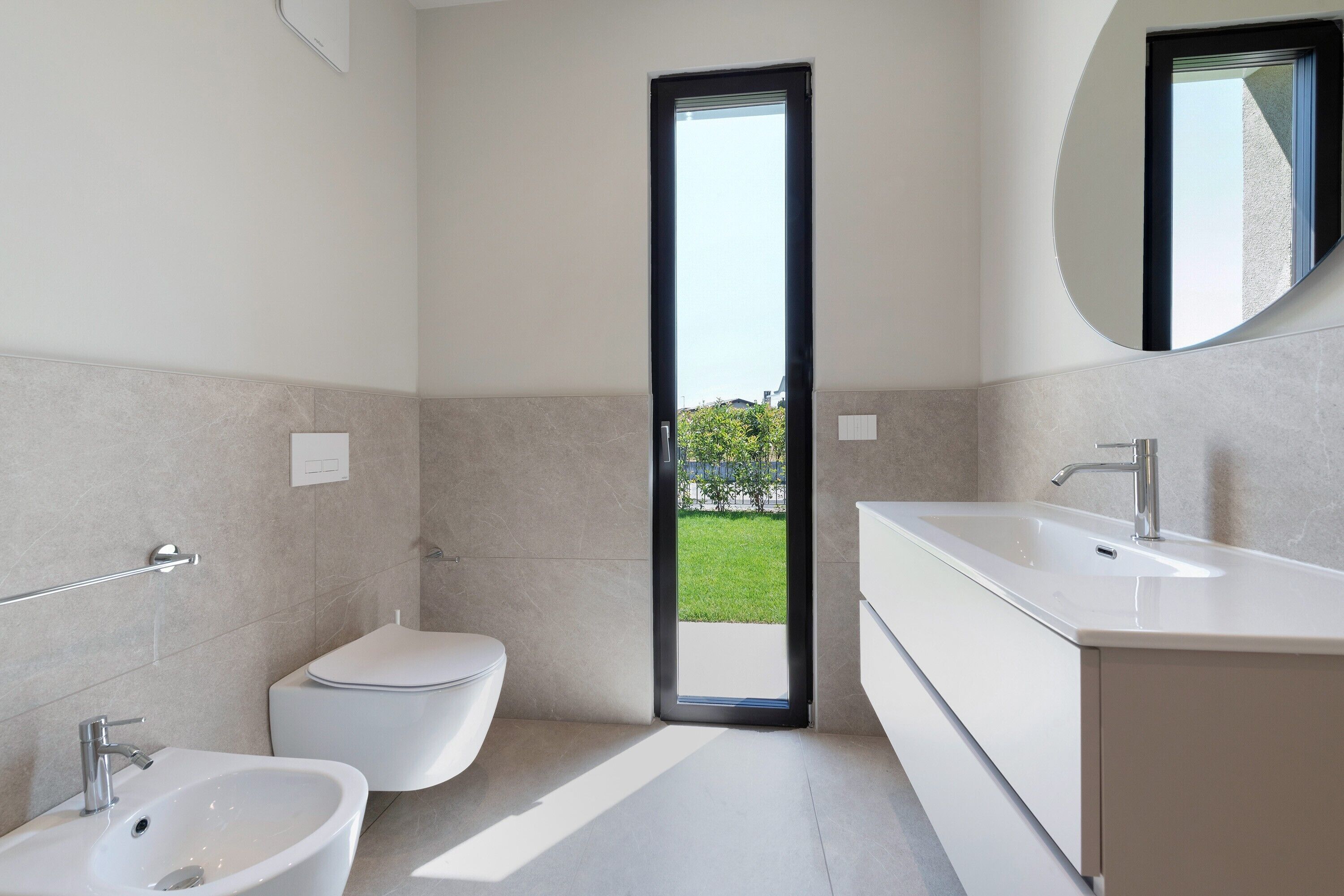 A modern bathroom with a toilet, bidet, and sink.