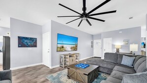 Uma sala de estar moderna com um sofá modular, uma mesa de centro e um ventilador de teto.